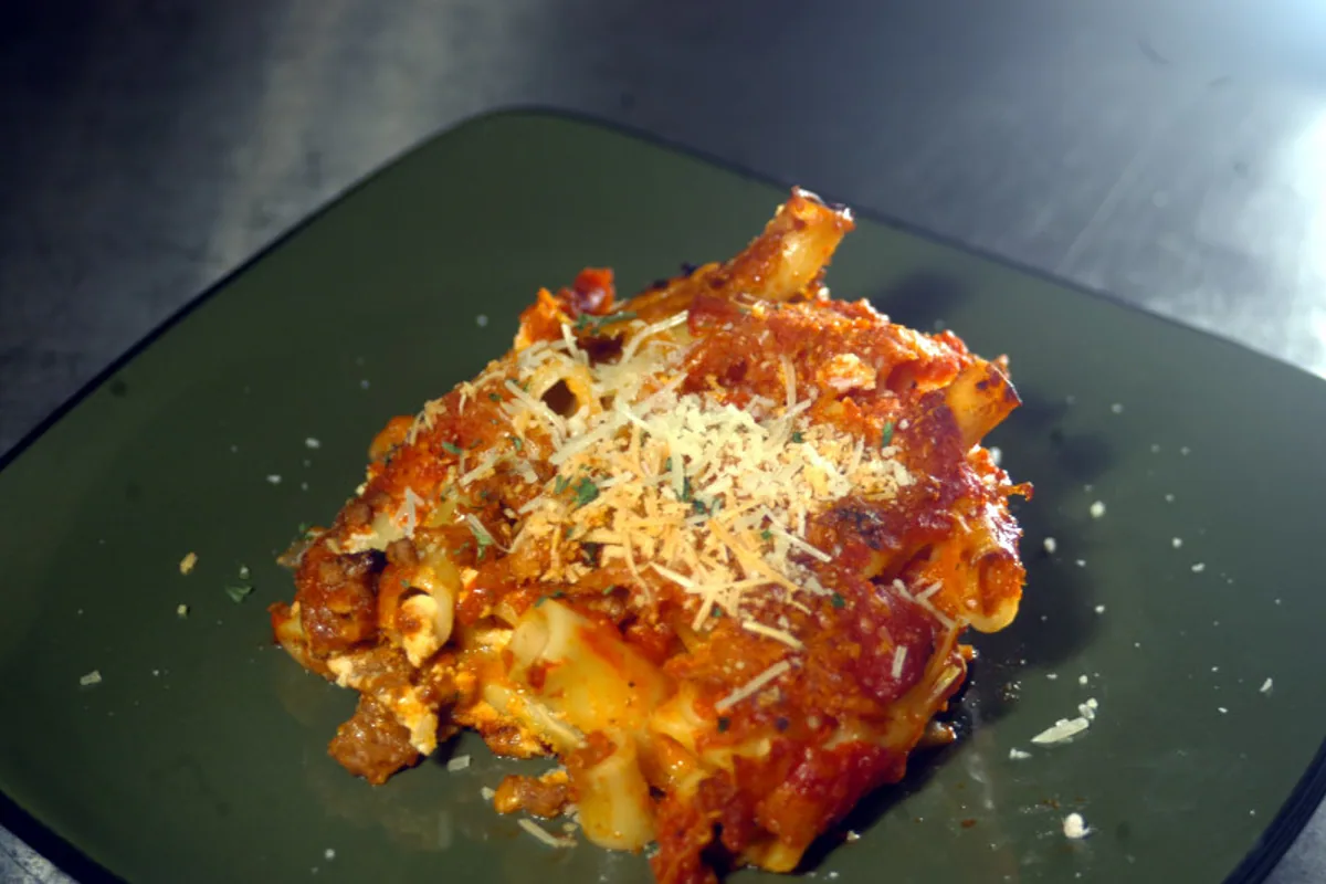 Plated baked ziti with tomato sauce and grated cheese