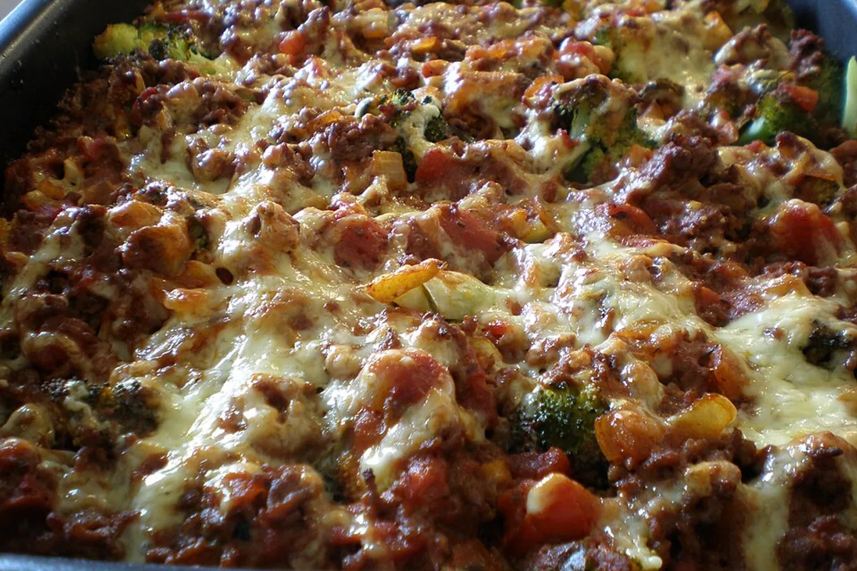 Cheesy noodle casserole with ground beef broccoli tomato sauce and browned cheese