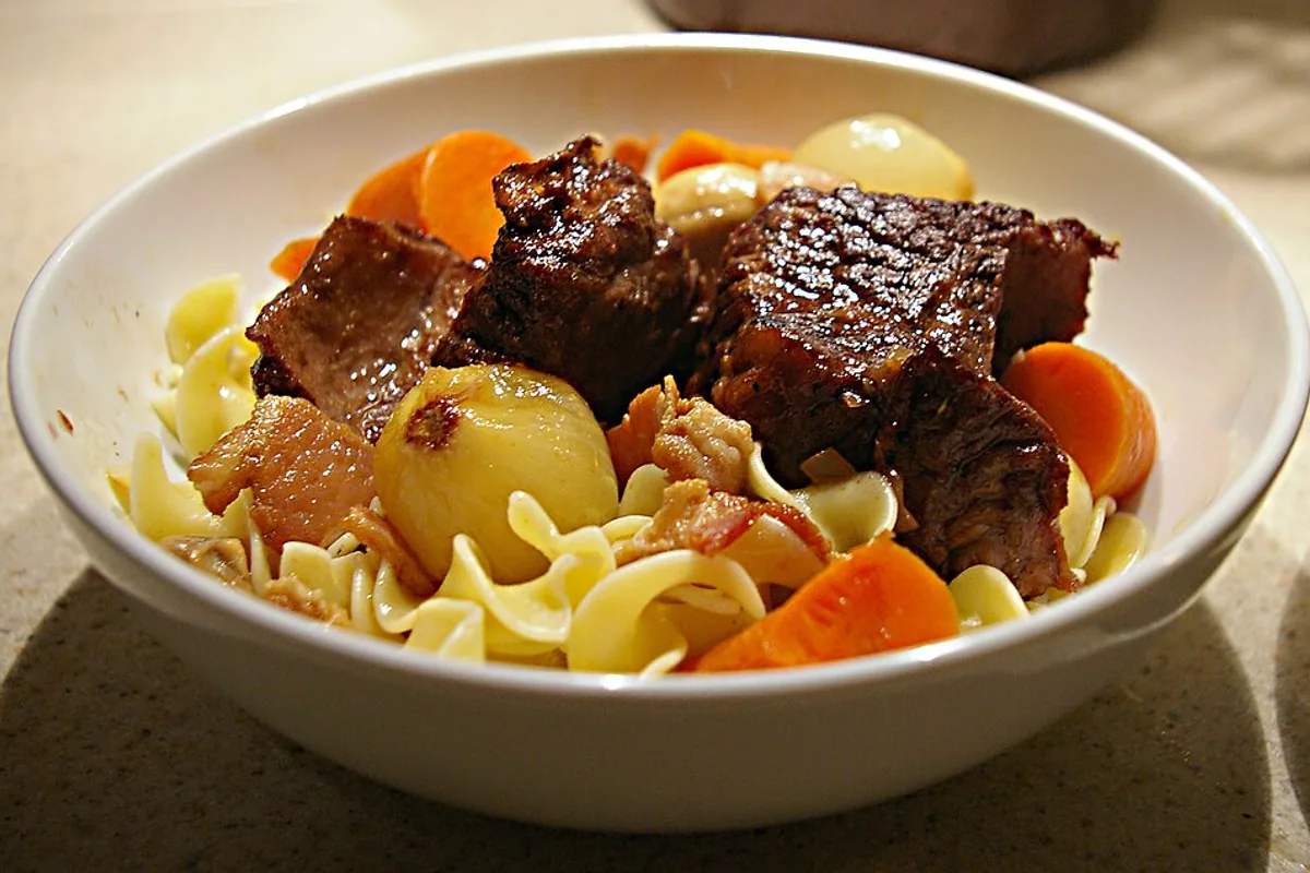 Glazed beef short ribs over egg noodles with carrots and pearl onions