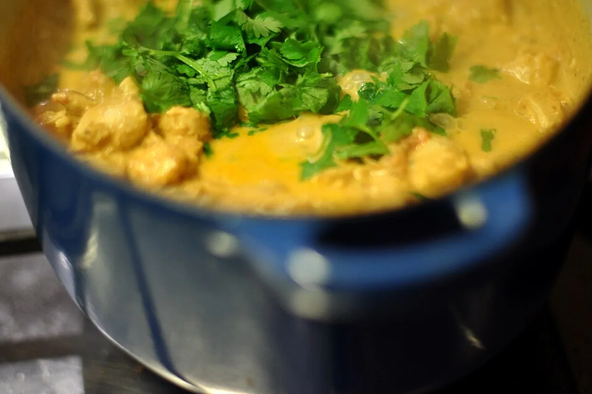 Butter chicken pieces in creamy orange tomato sauce topped with cilantro
