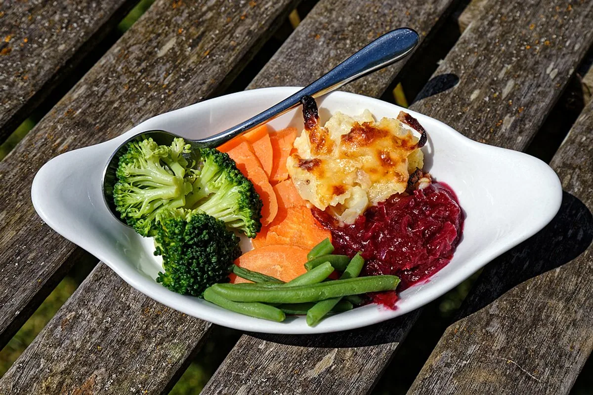 Cauliflower cheese with broccoli carrots green beans and red cabbage