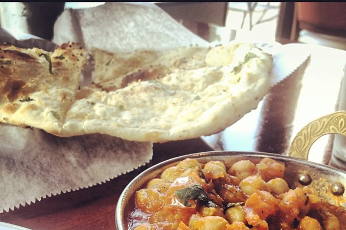 Chana masala chickpea curry served in a bowl with warm naan