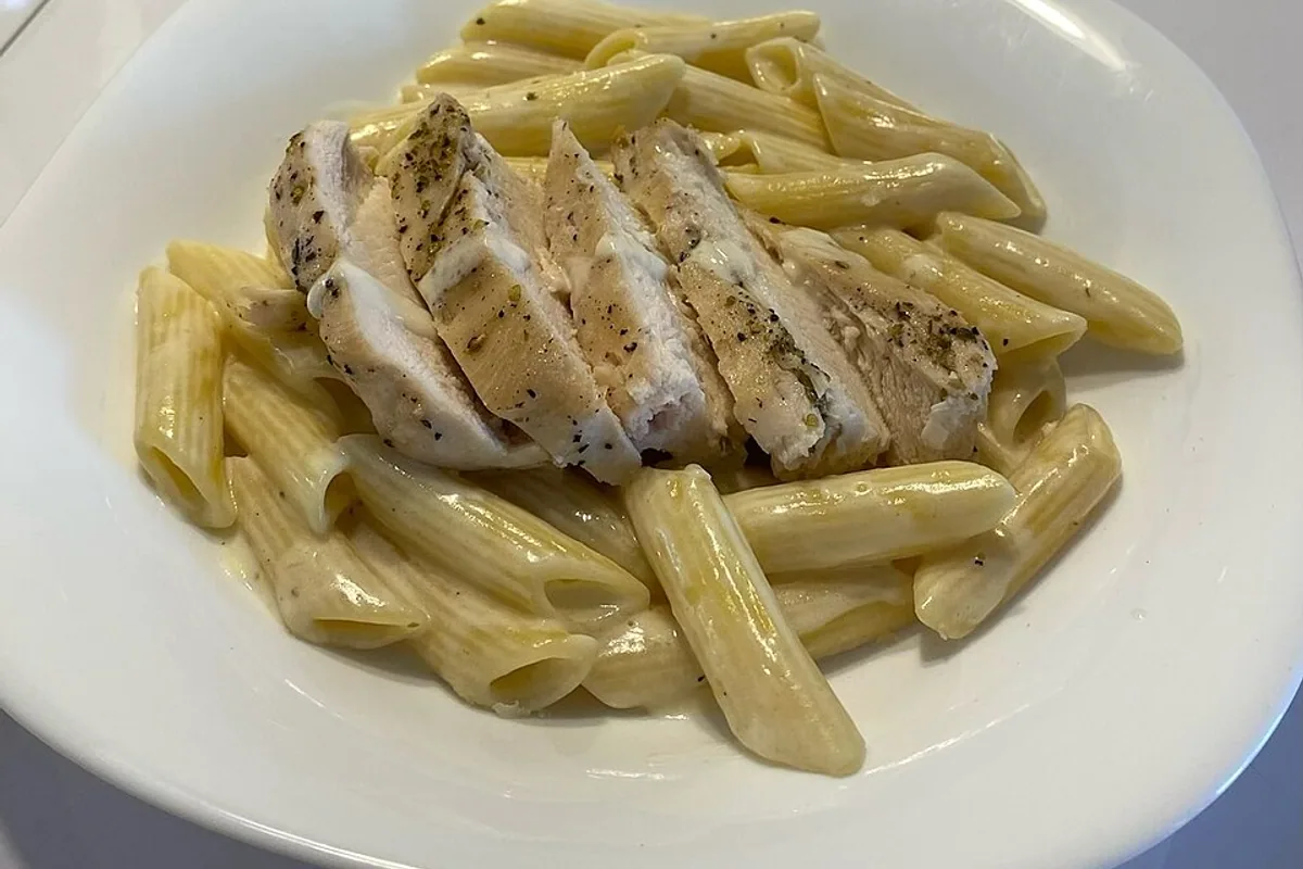 Sliced chicken breast over creamy Alfredo penne