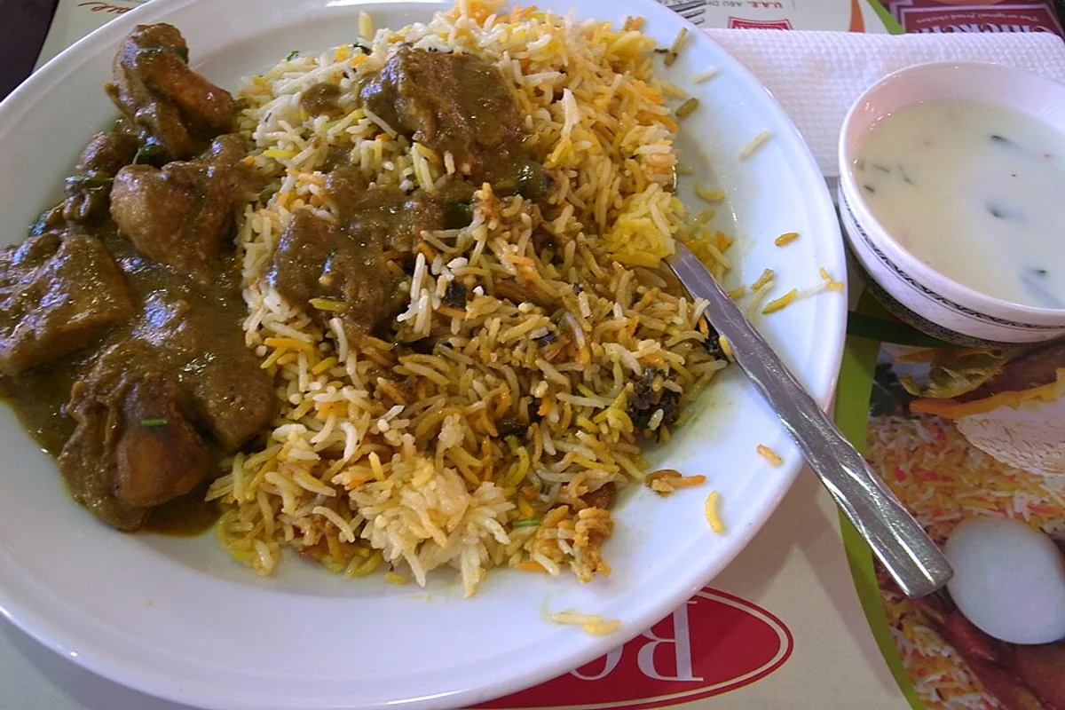Chicken biryani with long-grain rice fried onion herbs and yogurt sauce