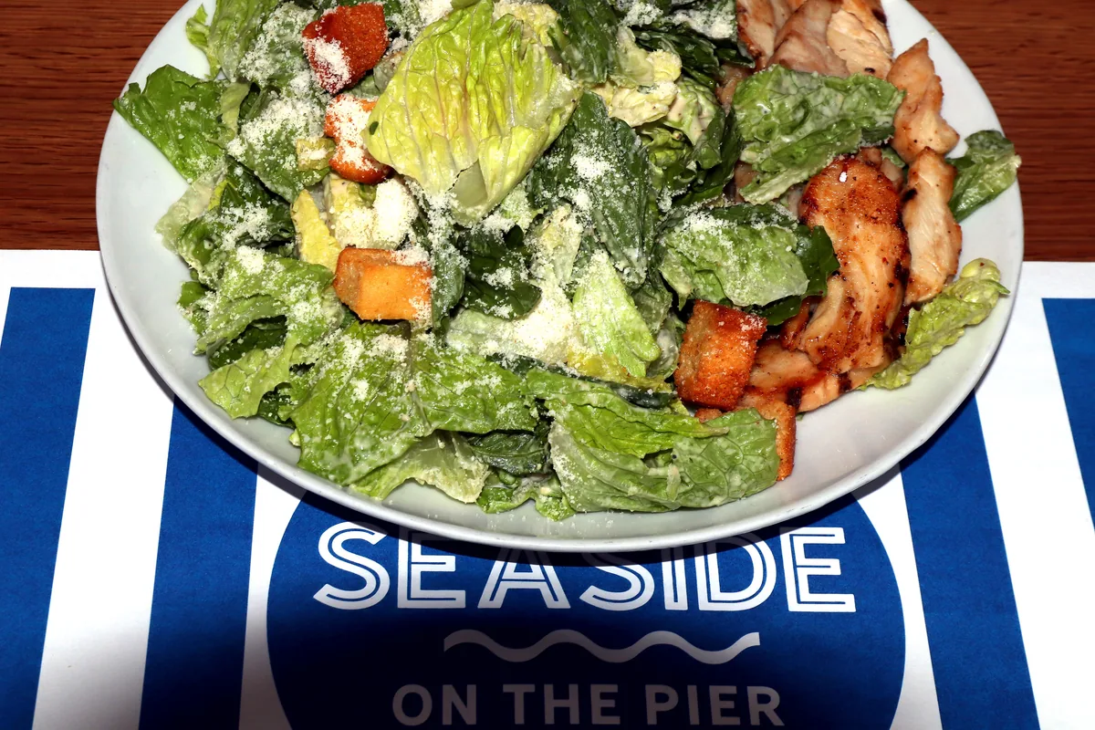 Caesar salad topped with grilled chicken croutons and Parmesan