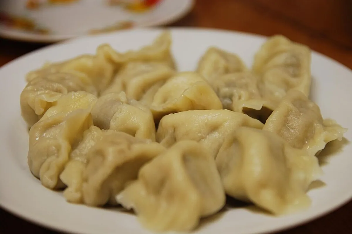 Plate of tender pan-steamed dumplings filled with chicken and mushrooms
