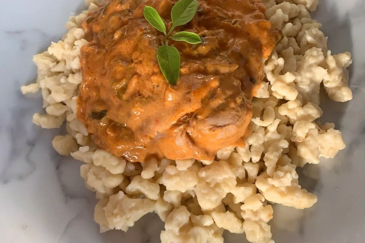 Chicken paprikash in creamy paprika sauce over small Hungarian dumplings