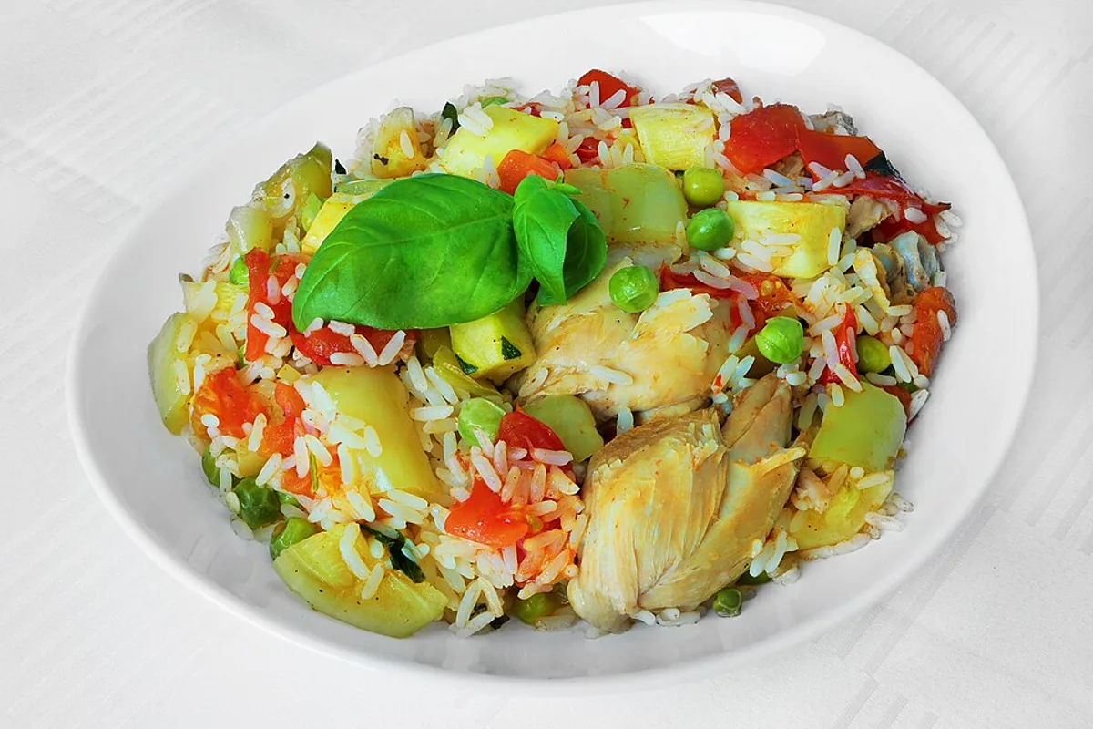 Rice salad with chicken peppers squash peas tomato and lettuce