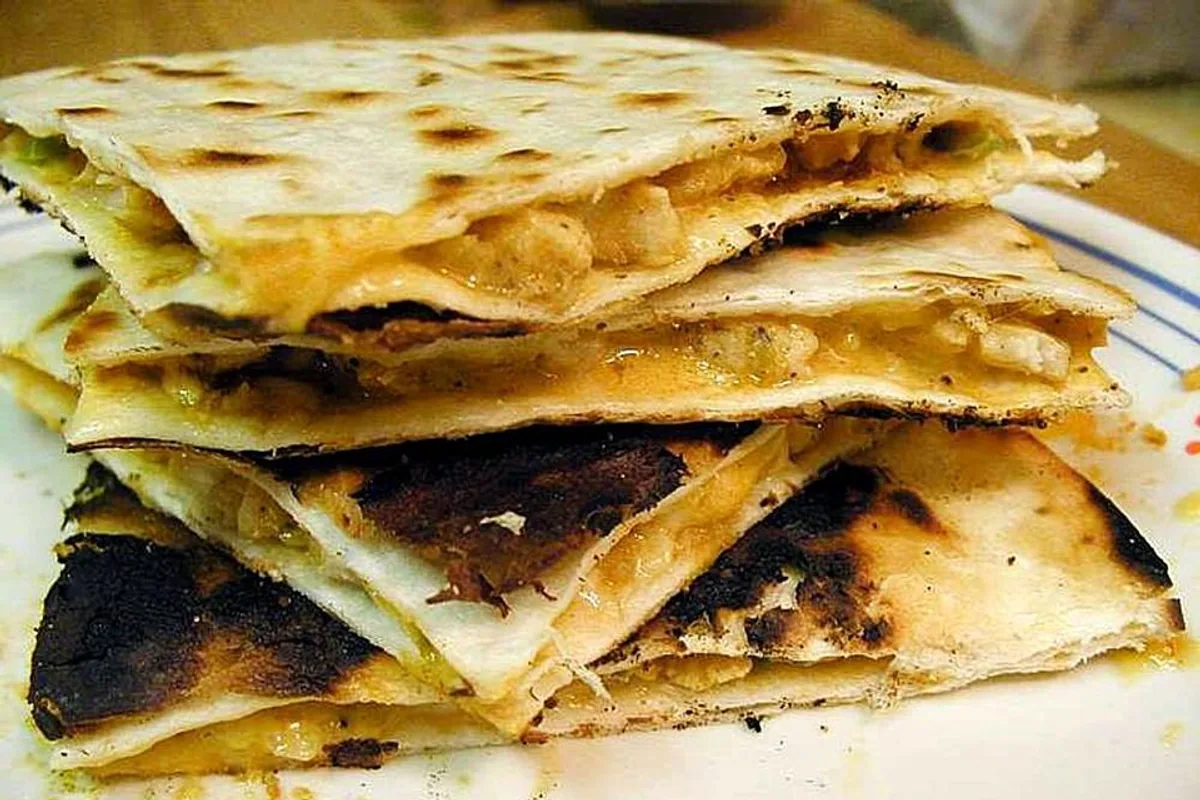 Stacked crisp chicken quesadilla wedges with melted cheese