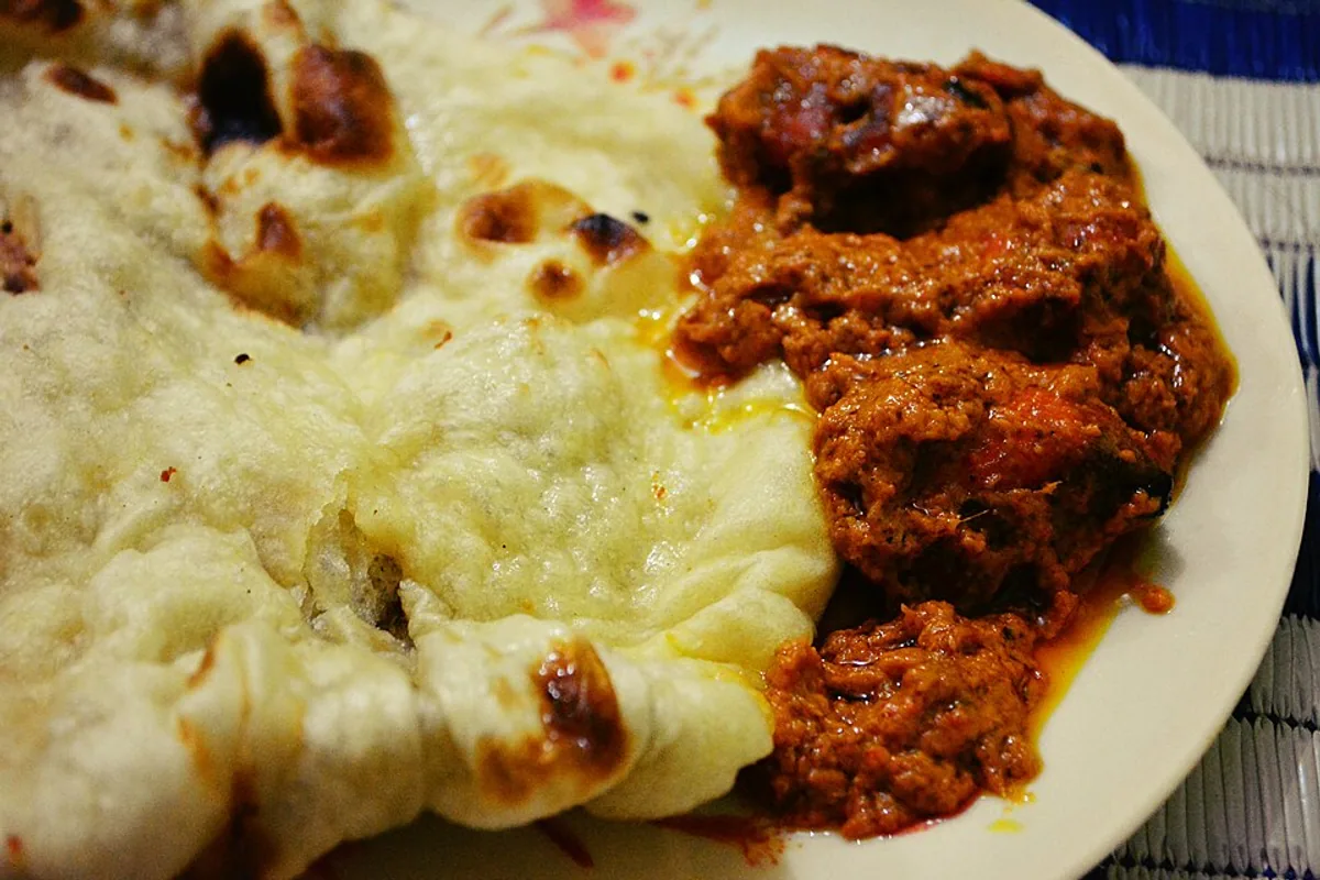 Chicken tikka masala in red sauce served with butter naan