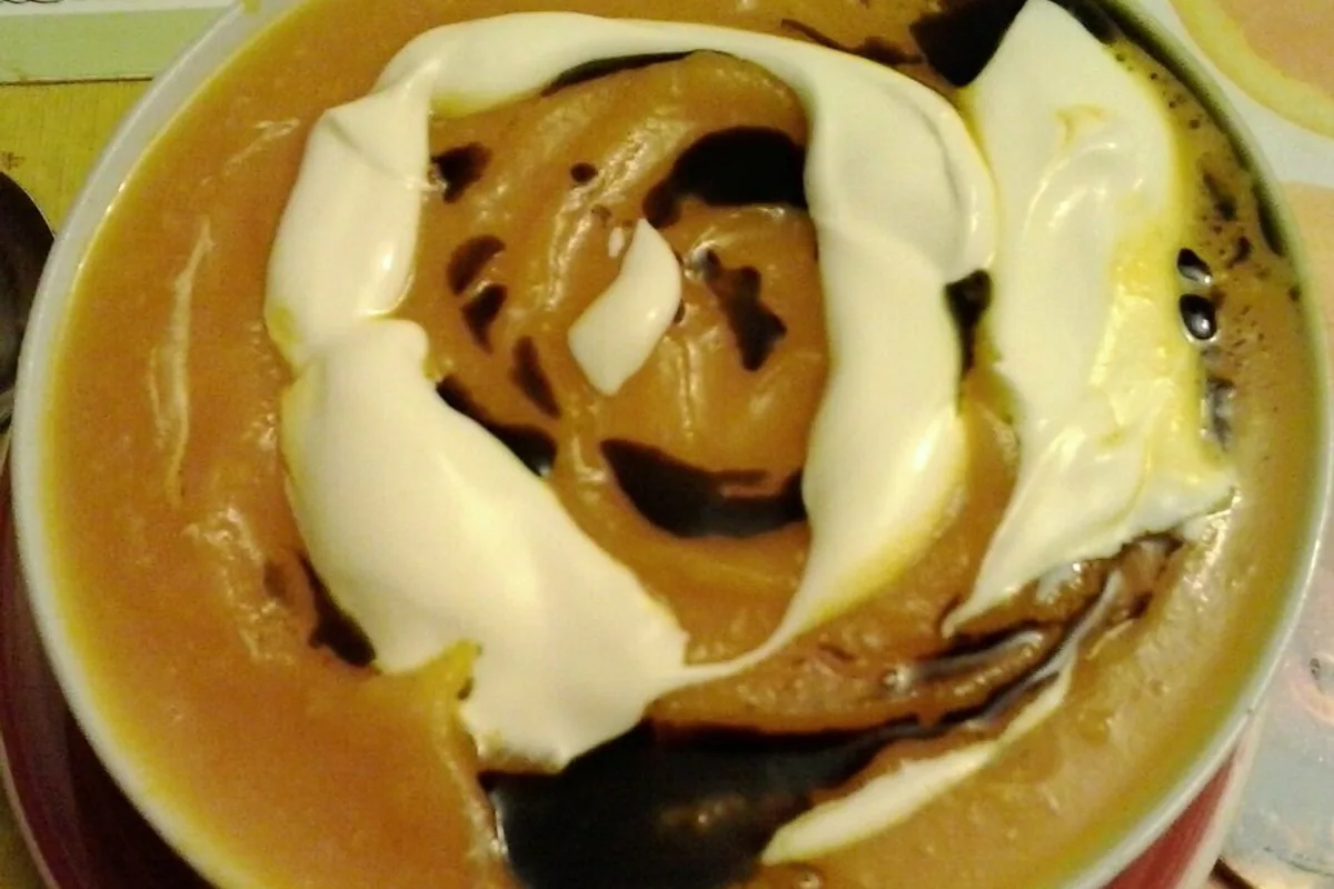 Creamy pumpkin soup with a sour cream swirl and pumpkin seed oil