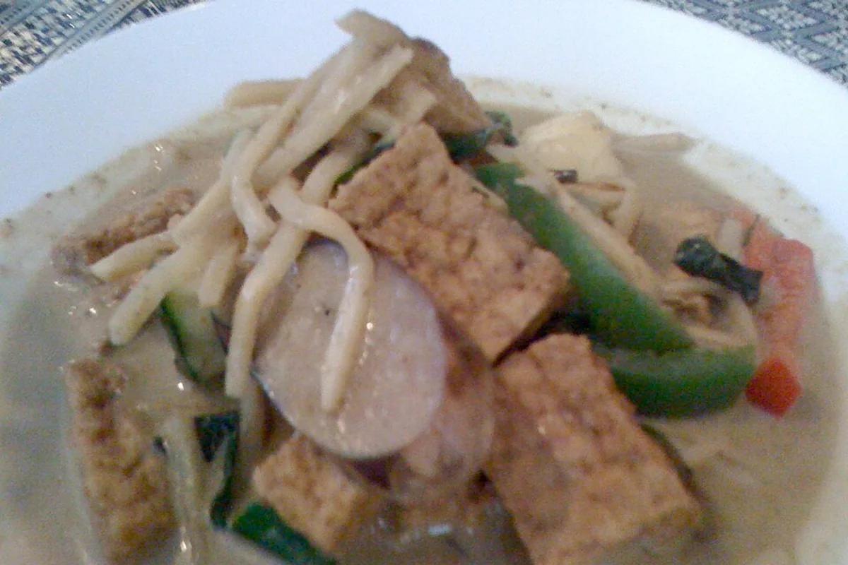 Tofu and vegetables in a green coconut curry broth with chiles and cilantro