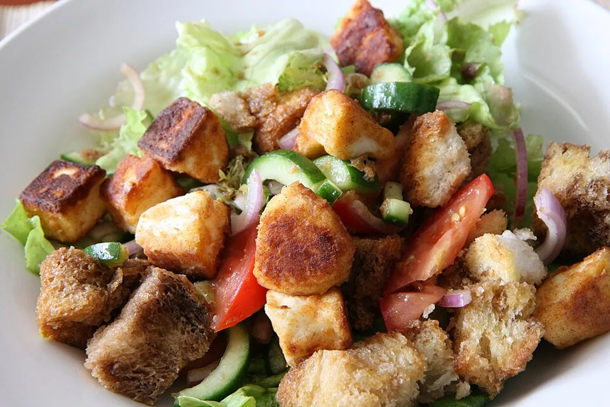 Panzanella salad with fried halloumi toasted bread tomato cucumber lettuce and red onion