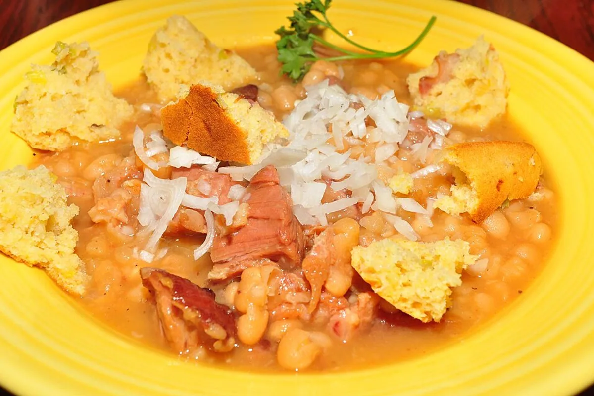Ham and white beans with white rice and pieces of cornbread