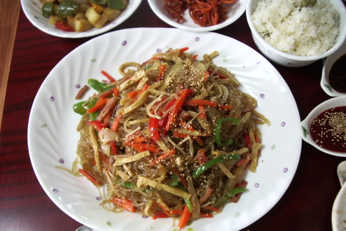 Japchae glass noodles with mushrooms carrots peppers and greens