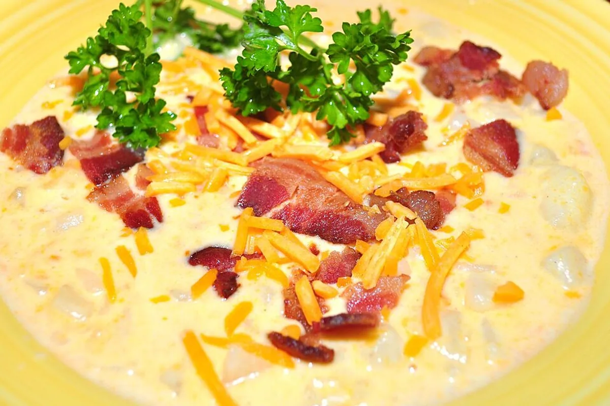 Creamy potato soup topped with cheddar bacon scallions and parsley