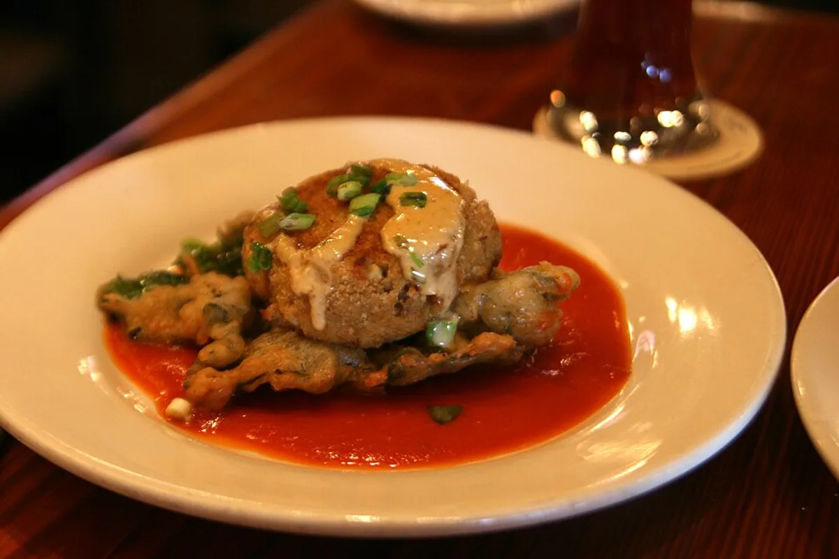 Golden Maryland-style lump crab cakes with greens lemon and sauce