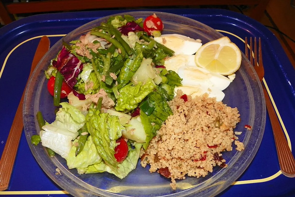 Tuna Nicoise salad with egg lettuce tomatoes green beans lemon and couscous