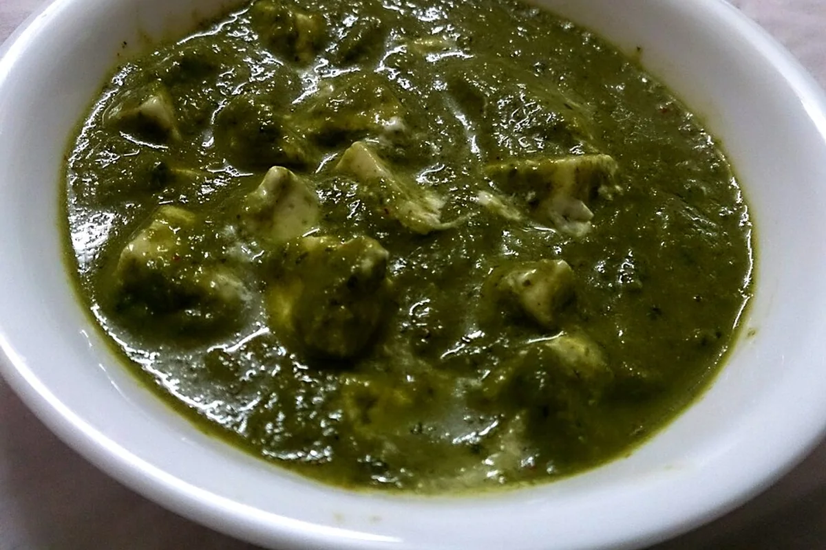 Paneer cubes in a thick bright green spinach gravy