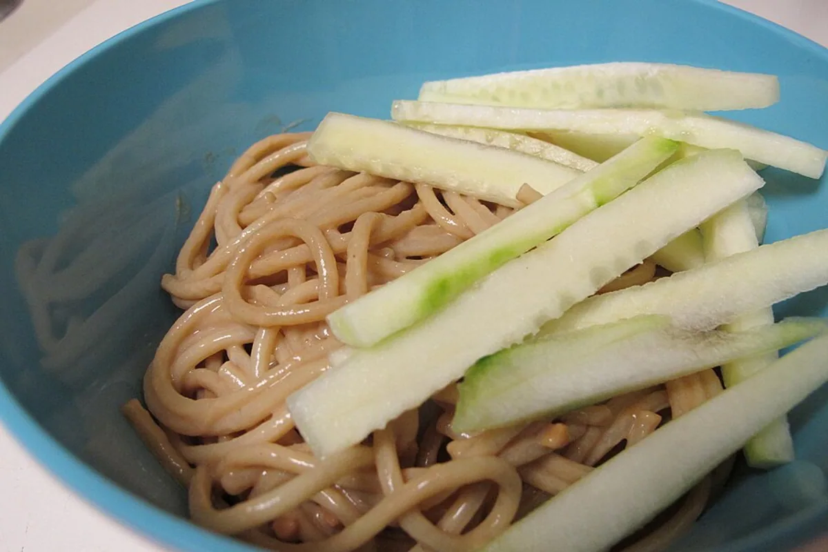 Cold peanut noodles topped with fresh cucumber matchsticks
