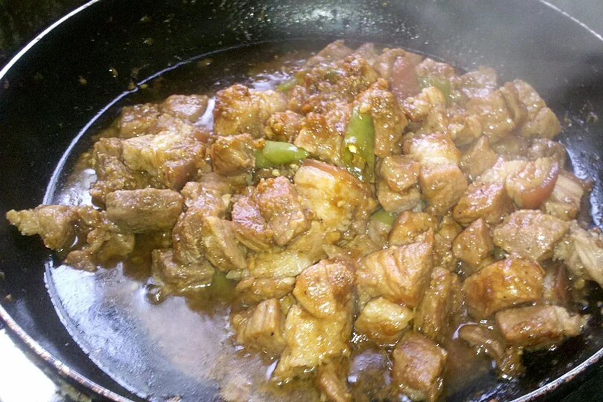 Tender pork adobo pieces with garlic in a glossy vinegar soy sauce