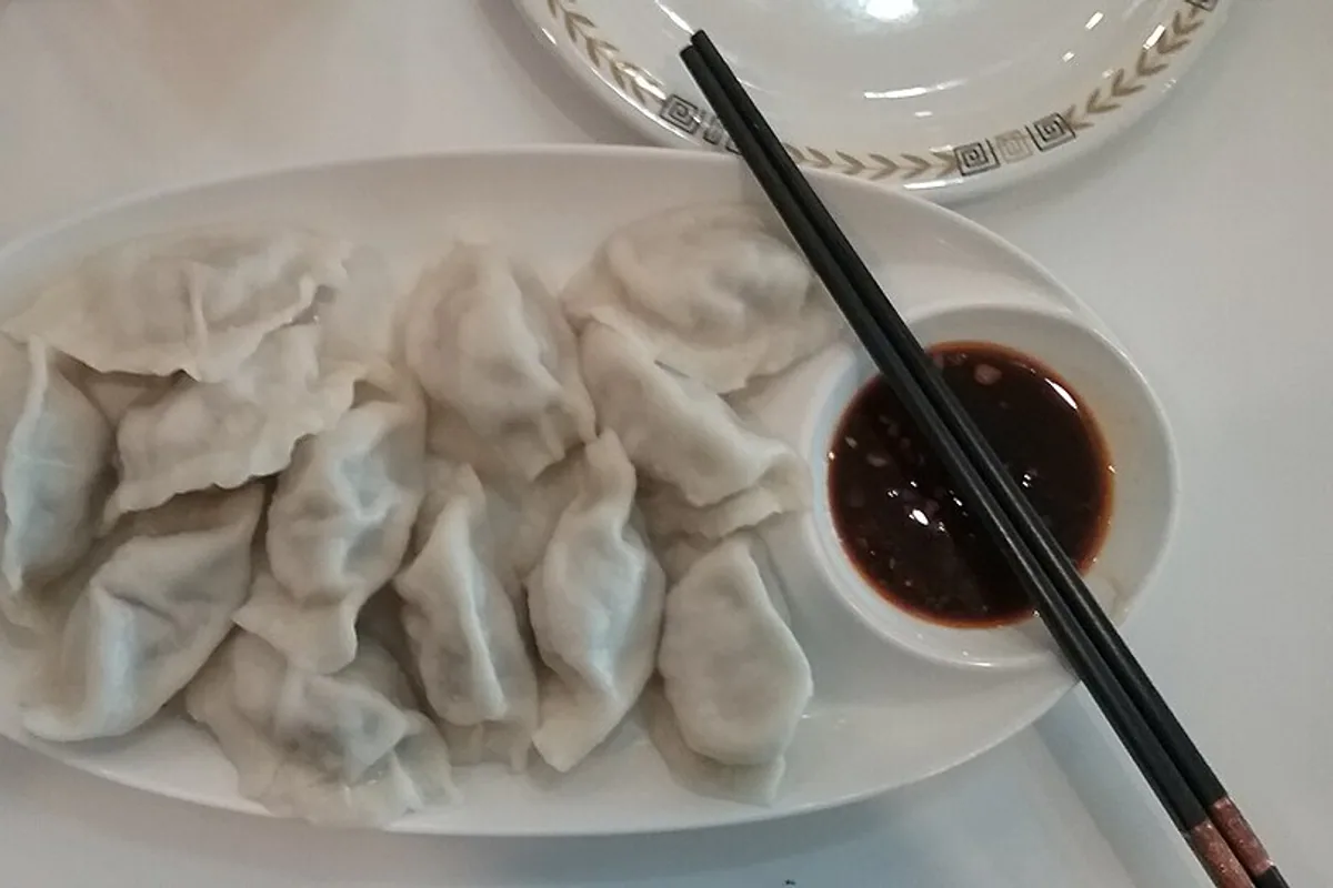 Boiled pork and napa cabbage dumplings served with dipping sauce