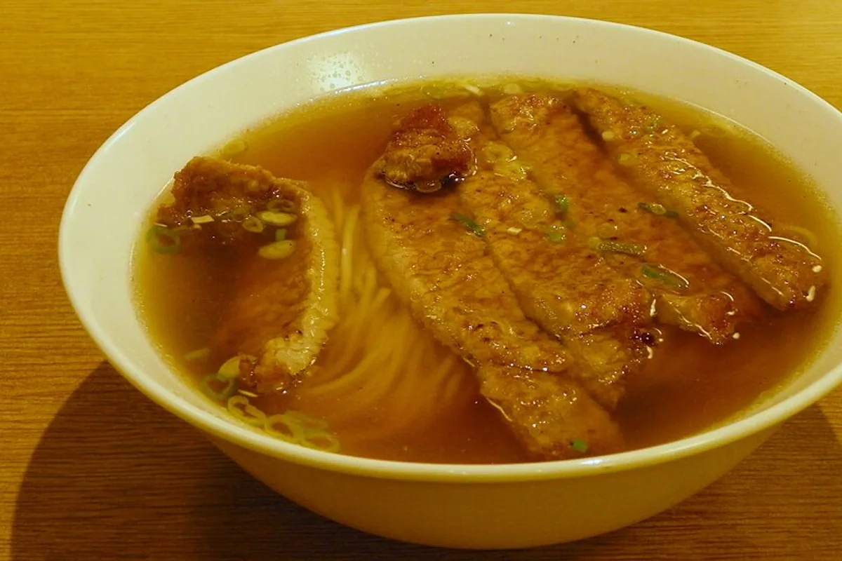 Crispy fried pork chop served with a bowl of clear noodle soup