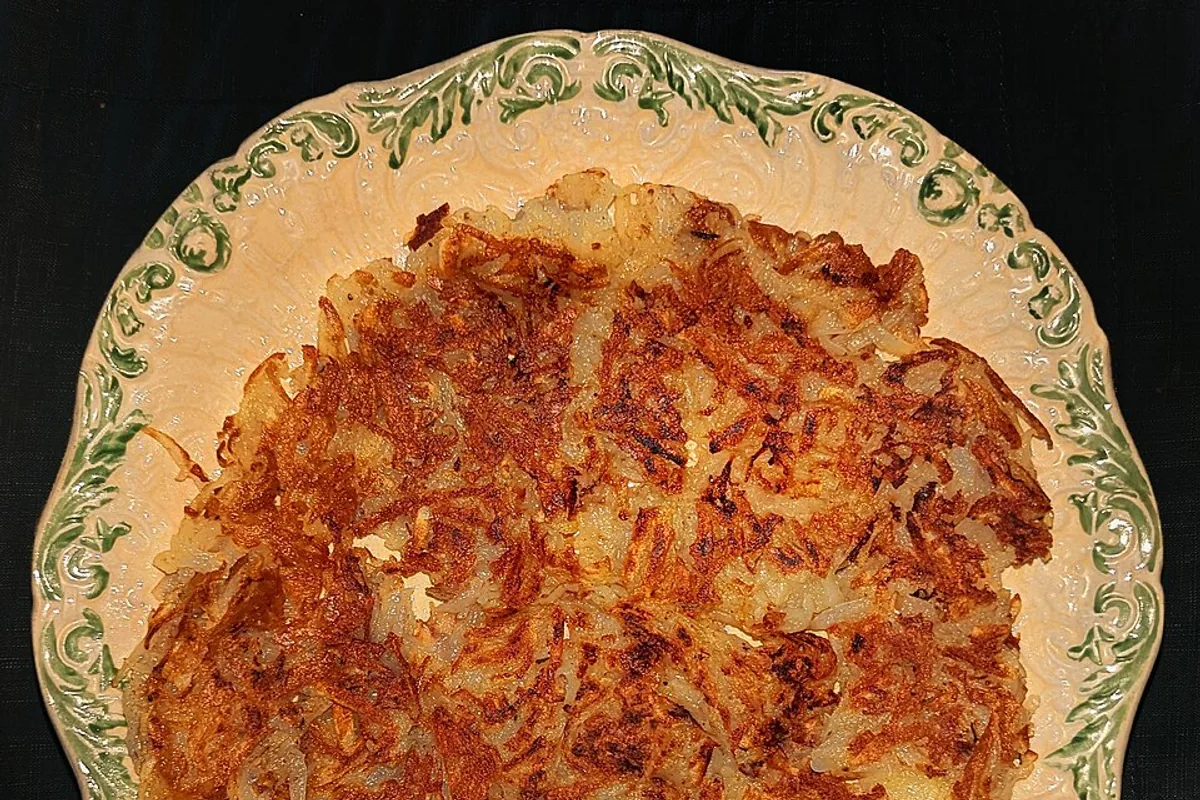 Large crisp golden potato pancake on a patterned plate