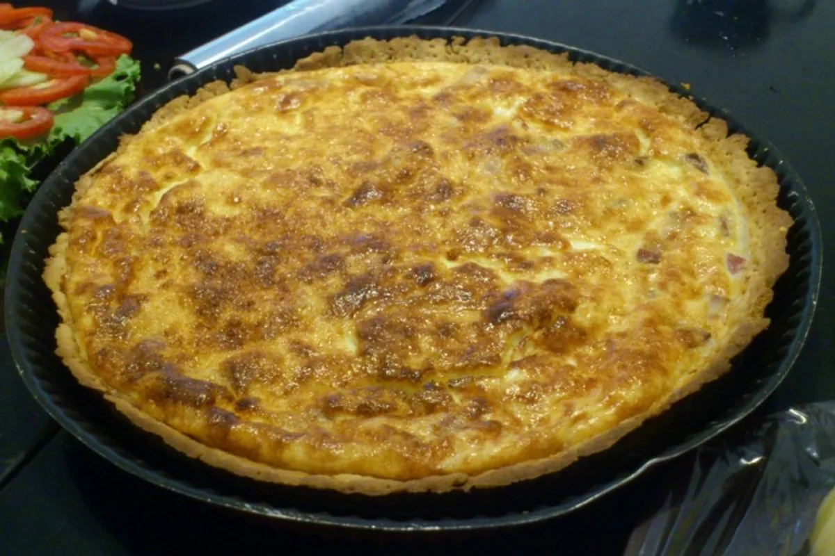 Whole browned Quiche Lorraine with bacon and Gruyere in a tart pan