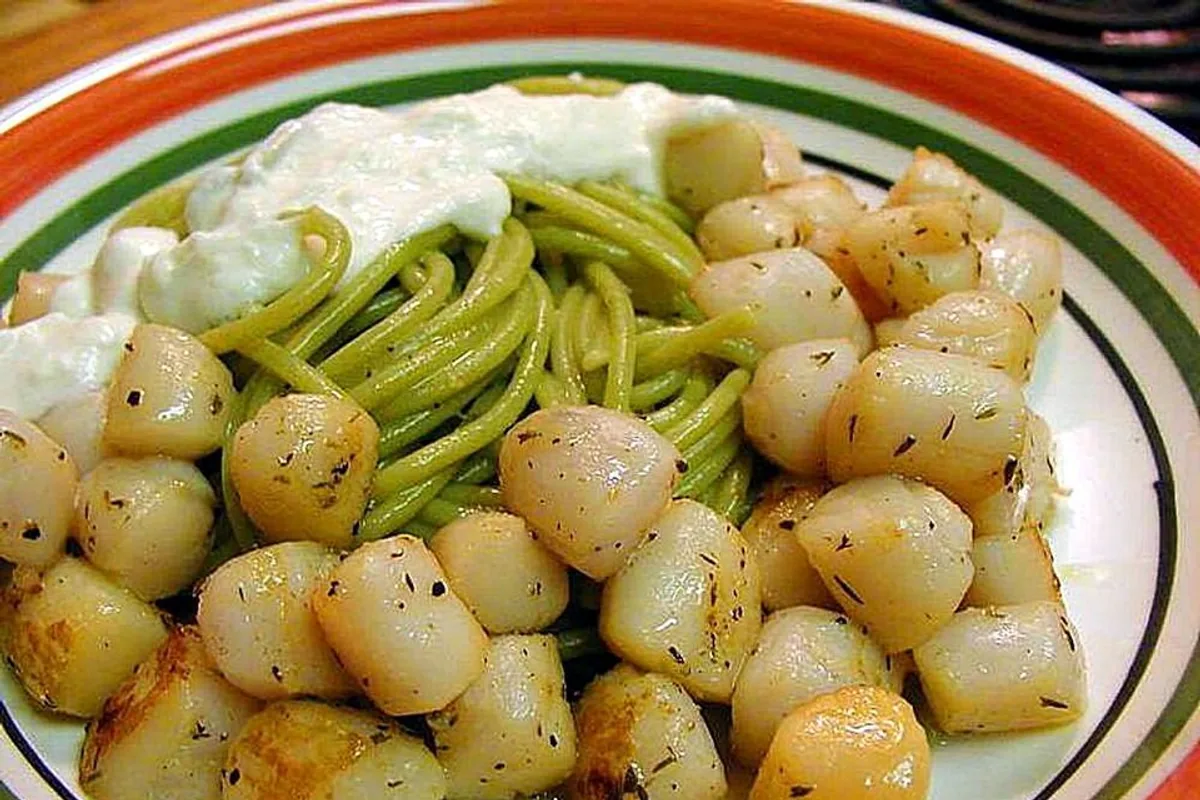 Seared scallops with green pasta and white cream sauce