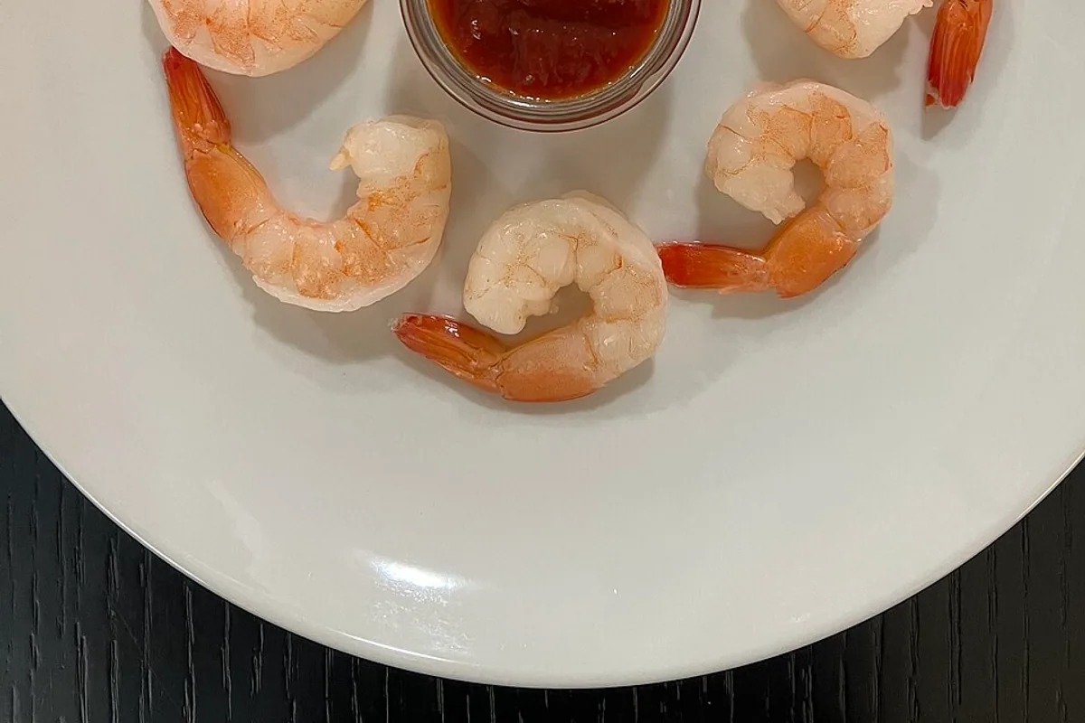 Plate with three portions of chilled cocktail shrimp and dipping sauce