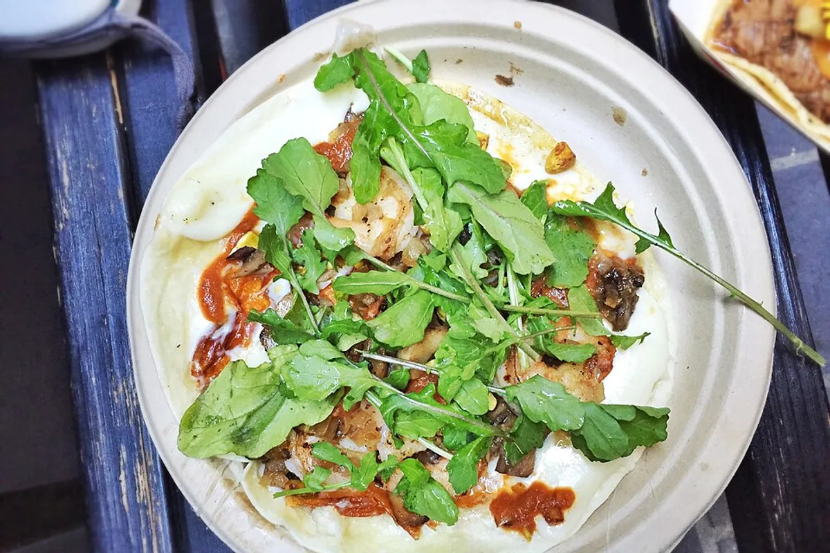 Shrimp and mushroom quesadilla with tomato chile sauce cheese market greens and pistachios