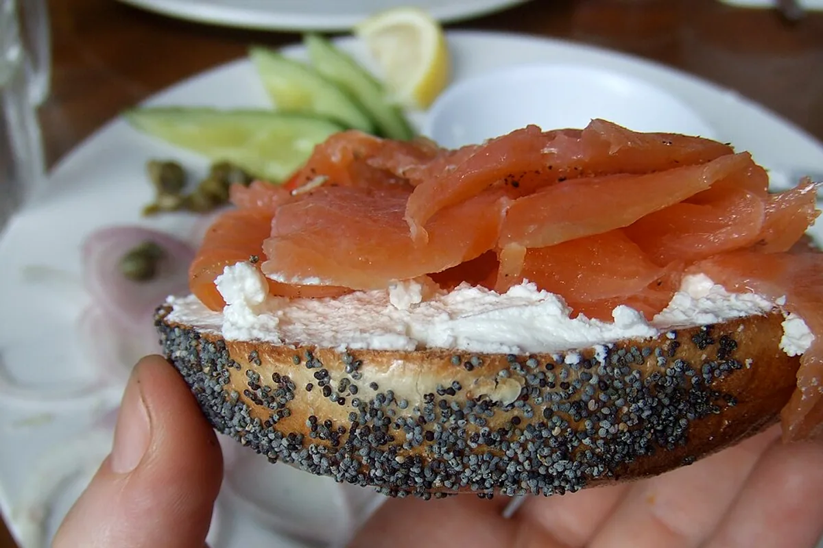 Poppy-seed bagel with cream cheese smoked salmon cucumber capers red onion and lemon