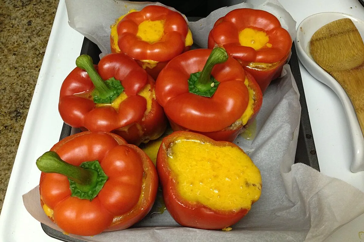 Red bell peppers filled with rice beans corn and melted cheese