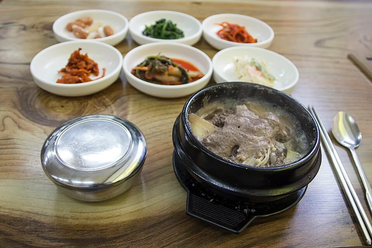 Stone bowl of Korean beef bulgogi hot pot served with rice and side dishes