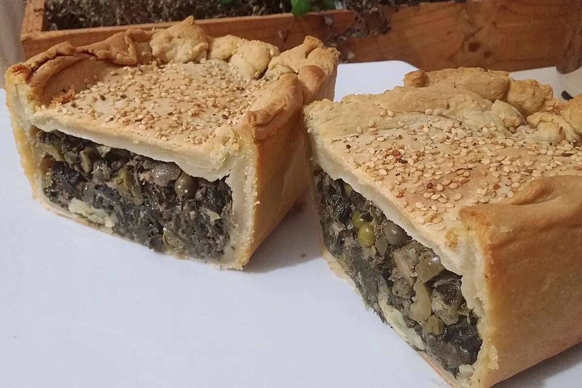 Sliced tuna and spinach savory pie with a flaky seeded crust