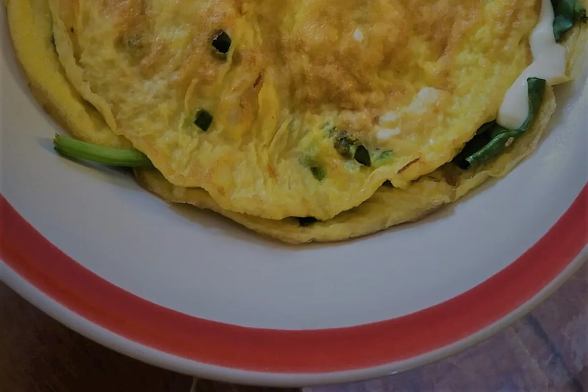 Golden folded omelet filled with spinach and melted cheese