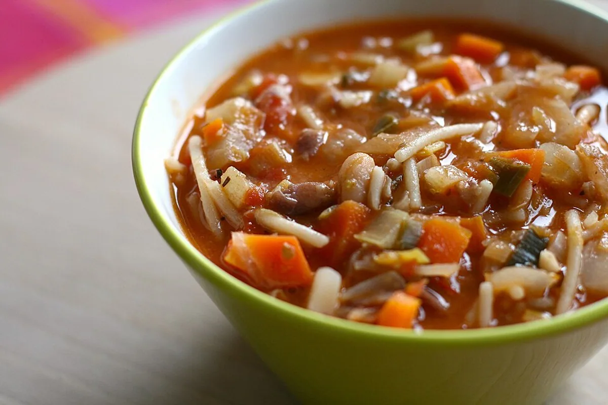Bowl of tomato minestrone with pasta beans carrots and vegetables