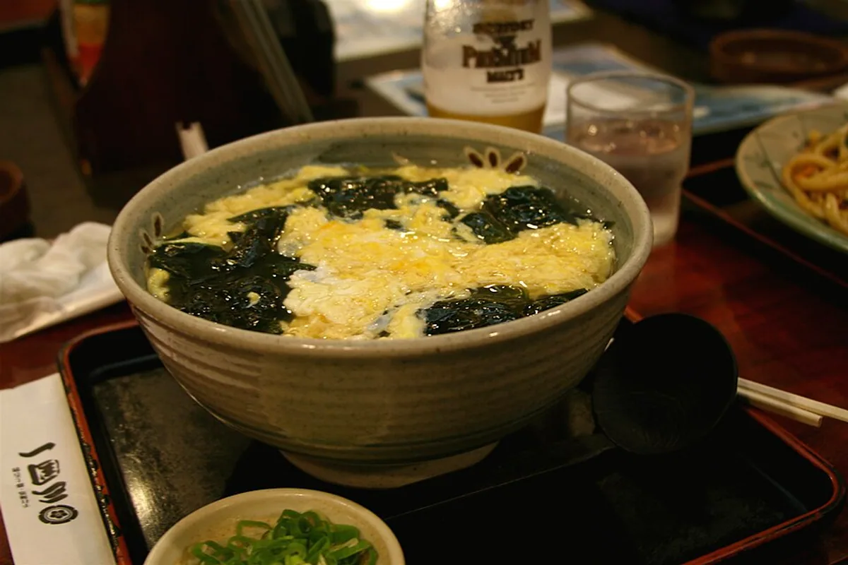 Wakame udon soup with thick noodles seaweed tempura crumbs and broth